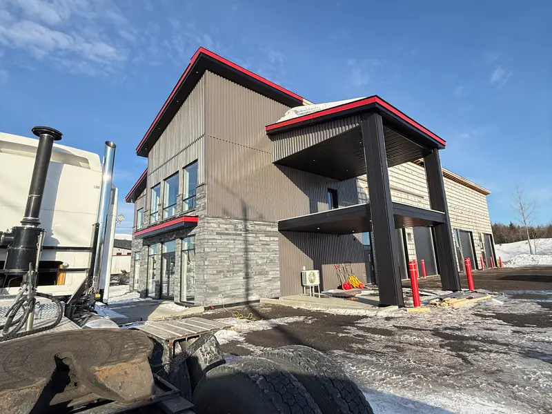 Bâtiment commercial avec revêtement d'acier beige, pierre et accents rouges